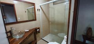 a bathroom with a sink and a glass shower at Pousada Cabanas Paraiso in Angra dos Reis