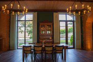 a dining room with a table and chairs and windows at Agarani Estate in Telavi
