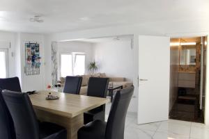 a dining room and living room with a wooden table and chairs at Chez Nadège in Affligem