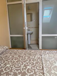 a bedroom with a bed and a bathroom with a sink at Veranda Guest House in Chornomorsk +63 photos