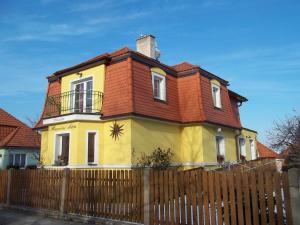 una casa amarilla y naranja detrás de una valla en Slunecni Dum, en Český Krumlov