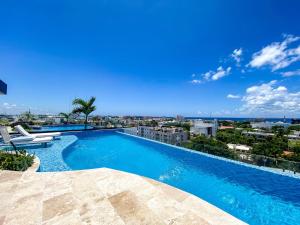 a large swimming pool with a view of the city at Downtown Playa Studio with Rooftop Pool Steps to Everything in Playa del Carmen