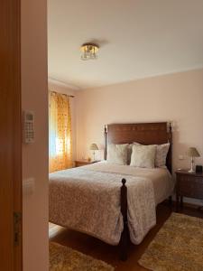 a bedroom with a large bed and a window at Casa7pias in Ponte de Lima