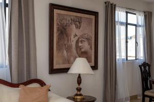 a bedroom with a painting on the wall and a lamp at Departamento Victoria in San Juan de los Lagos