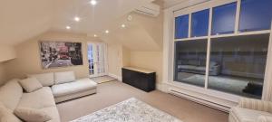 a living room with a white couch and a large window at Couchiching Summer Escape in Orillia