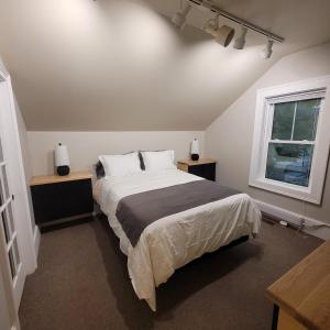 a bedroom with a large bed and a window at Couchiching Summer Escape in Orillia