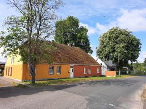 a yellow and orange house on the side of a street at Ferienhaus am Vilzsee, Mirow in Diemitz