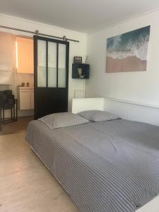 サント・マキシムにあるNice studio with terrace and gardenのベッドルーム1室(ストライプ掛け布団付きのベッド1台付) +12枚の写真