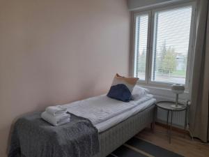 a small room with a bed with a window at Convenient Apartment for 3 in Oulu