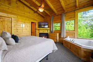 une chambre avec un lit, une cheminée et une baignoire dans l'établissement Luxury Lodge and Resort- Hot Tub, Fire Pit, Game Room, Pets, à Sevierville 41 autres photos