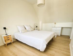 ペロス・ギレックにあるTI GWER - Superbe maison en pierre Ploumanachの白いベッドルーム(大型ベッド1台、ナイトスタンド付)