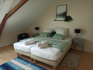 Cossé-le-VivienにあるGite La ferme aux vachesの屋根裏にあるベッドが2つある寝室