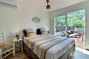 a bedroom with a bed and a large window at Les Gites de Namaskar in Labégude