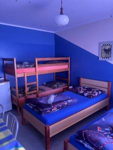 a room with two bunk beds and a blue wall at Agroturystyka Willa Ola in Giewartów