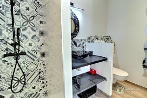a bathroom with a shower with a sink and a toilet at Les Gites de Namaskar in Labégude