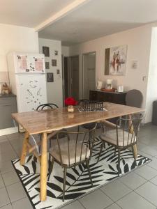 a kitchen with a wooden table and chairs at Maison aux portes de sologne in Vierzon