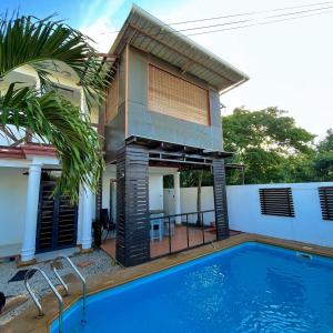 a villa with a swimming pool in front of a house at Sandy Lane Escape - Grand Baie in Grand Baie