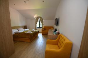 ein Hotelzimmer mit zwei Betten und einer Couch in der Unterkunft Za Jeziorem in Sztum