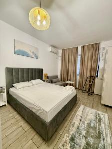 a bedroom with a large bed and a couch at Luxury beach studio in Mamaia Nord
