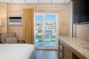 a bedroom with a bed and a kitchen with a balcony at Boothbay Harbor Inn in Boothbay Harbor