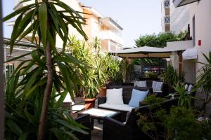an outdoor patio with chairs and tables and plants at Hotel Berna in Eraclea Mare