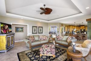 a living room with couches and a ceiling fan at Hale Aikane in Kailua-Kona