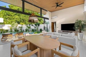 an open living room with a wooden table and chairs at Samudo 3br Tropical Haven in Bophut