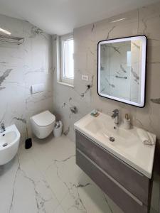 a white bathroom with a sink and a toilet at House Nina in Krk