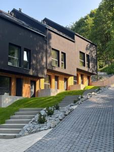 a building with a stone path in front of it at WIDOQ Resort Szczyrk in Szczyrk