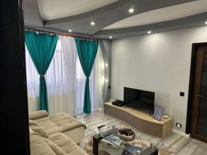 a living room with a couch and a television at G&A Luxe Apartment Central in Târgu Jiu