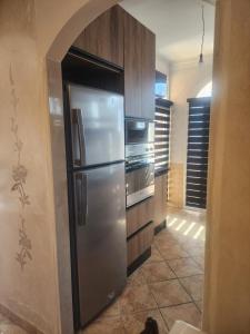 a kitchen with a stainless steel refrigerator and cabinets at Kalaat El Mansouria in Mansouria