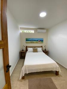 a bedroom with a white bed and a window at Casa Praia - Recanto Tucuns Beira-Mar in Búzios