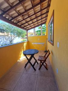 a table and a chair on a balcony at Casa Praia - Recanto Tucuns Beira-Mar in Búzios