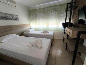 a hotel room with two beds and a desk at Fotis Resort in Iraklitsa
