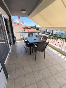 a patio with a table and chairs on a balcony at Fotis Resort in Iraklitsa