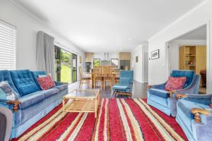 a living room with blue couches and a table at All Inn in Rotorua