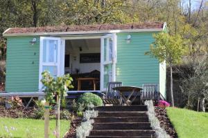 a green tiny house with a porch and stairs at Lulla Cottage in Lulla