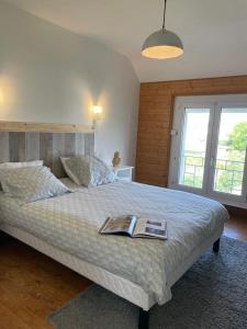 a bedroom with a large bed with a book on it at La maison de Sophie à Saint Pol de Léon in Saint-Pol-de-Léon