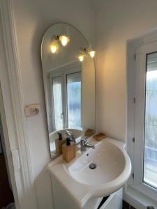 a bathroom with a sink and a mirror at La maison de Sophie à Saint Pol de Léon in Saint-Pol-de-Léon