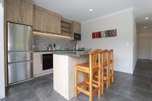 a kitchen with wooden cabinets and a stainless steel refrigerator at All Good in Rotorua