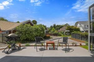 a patio with chairs and a table and a grill at All Good in Rotorua