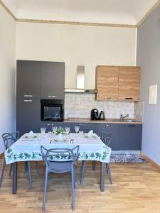 a dining room with a table and a kitchen at CASA ARUCI in Avola