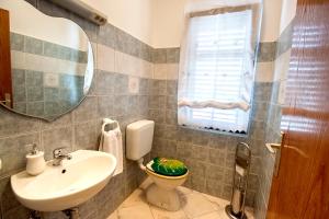 a bathroom with a sink and a toilet and a mirror at Apartman Orbanići in Orbanići +37 photos
