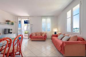 a living room with a couch and a table and chairs at Beaulieu Garden Apartment in Beaulieu-sur-Mer