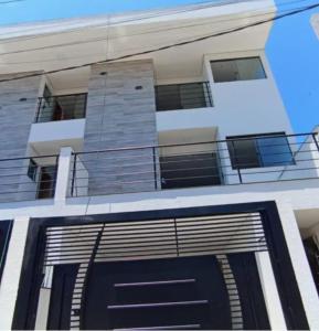 a building with a garage door and a balcony at Suíte 14 Família in Pontal do Paraná
