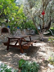 a wooden picnic table in a park with a tree at Olive grove mansion - kösedere village in Karaburun