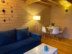 a living room with a blue couch and a table at Rewalia in Rewal