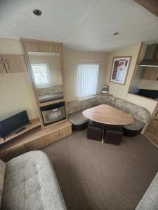 a living room with a table and a couch at 3 Bed Caravan - Sleeps 8 - Pets - Parking in Rhyl