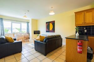 un salon avec deux canapés et une cuisine dans l'établissement Budget Friendly 3 Bed Apartment, à Galway 14 autres photos