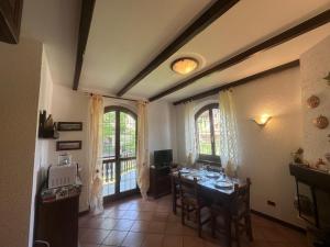 una sala da pranzo con un tavolo e due finestre di Rifugio Dei Girasoli a San Giacomo